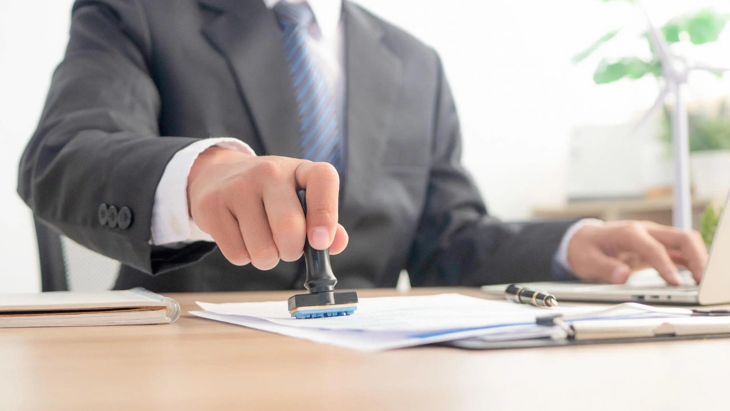 Person stamping document at a desk.