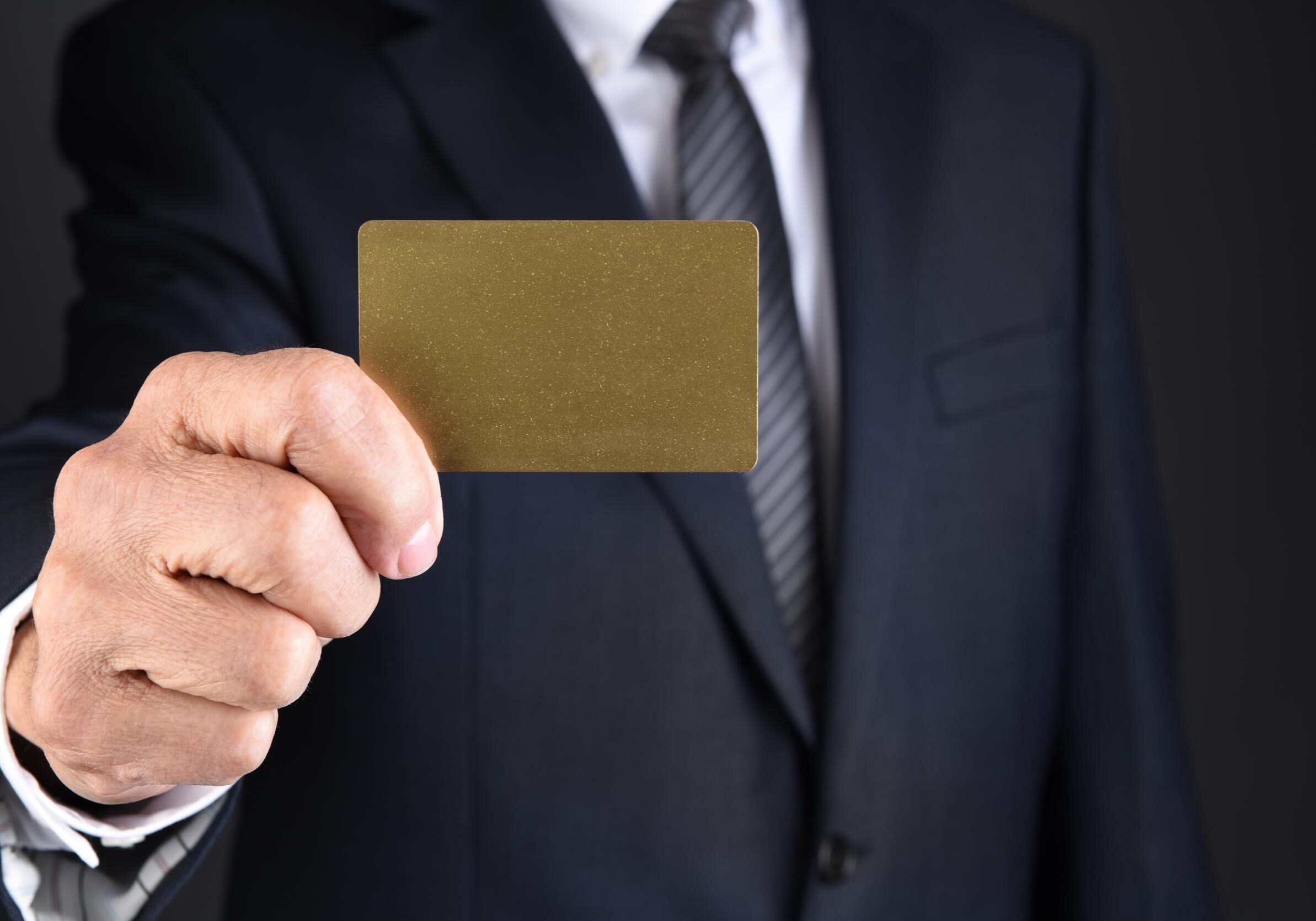 Person holding a gold card forward.