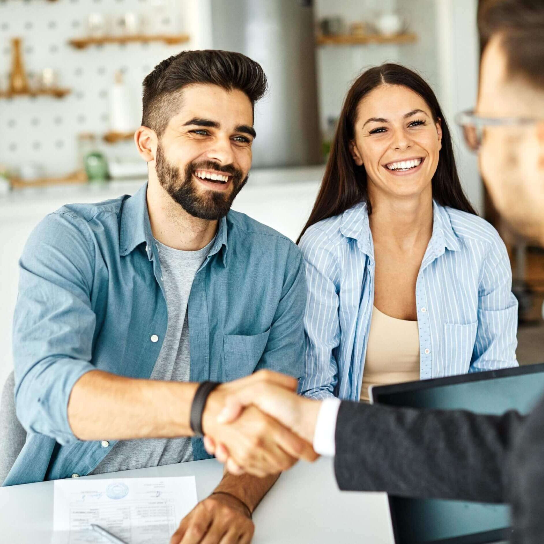 Couple shaking hands with business professional.